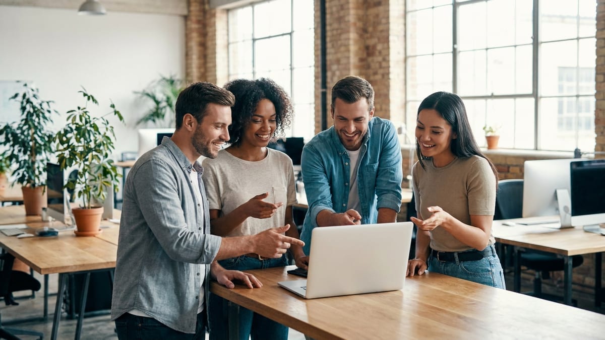 A small team collaborating around a laptop in a startup office